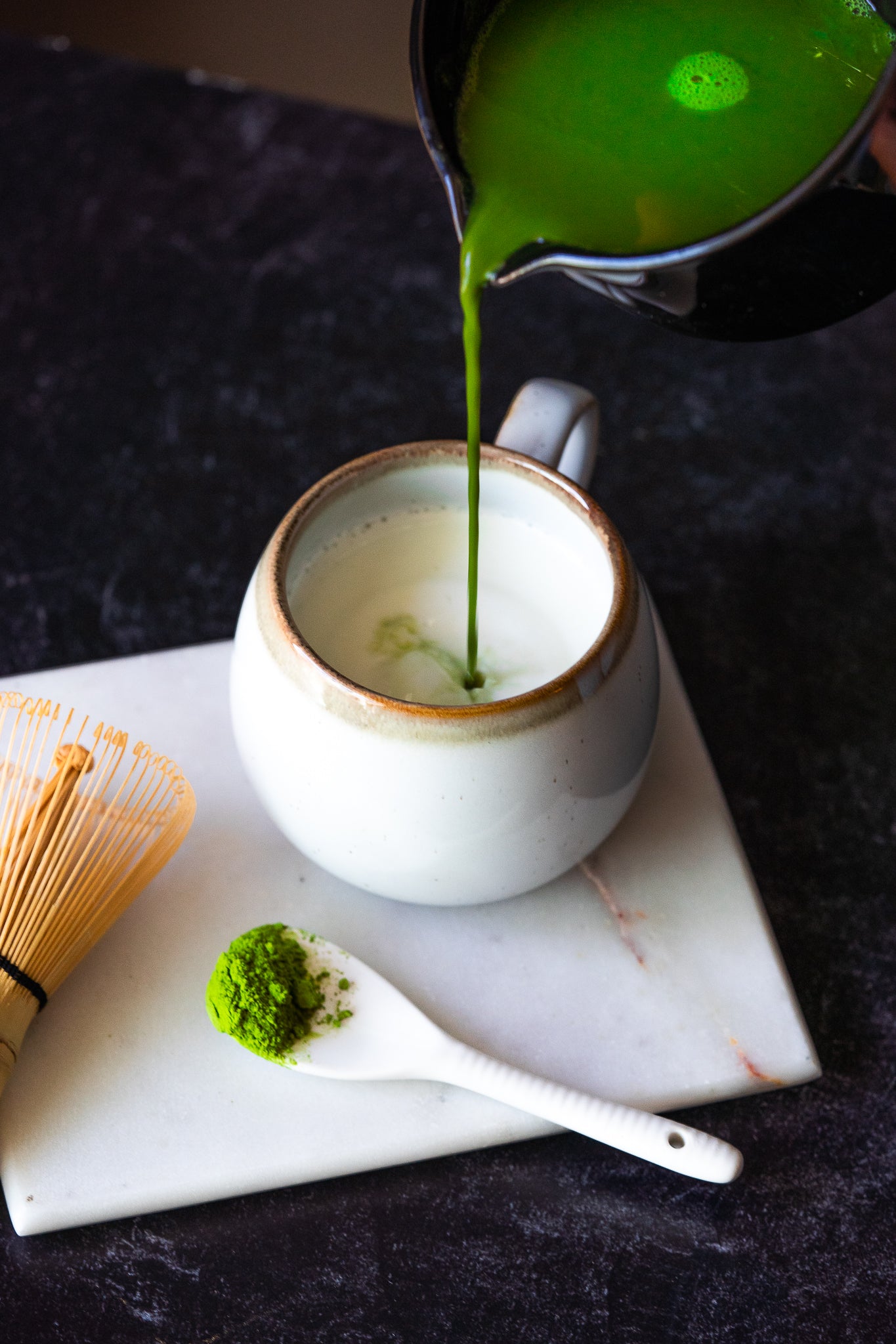 Matcha green tea being poured into a mug